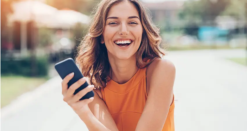 smiling woman holding cell phone